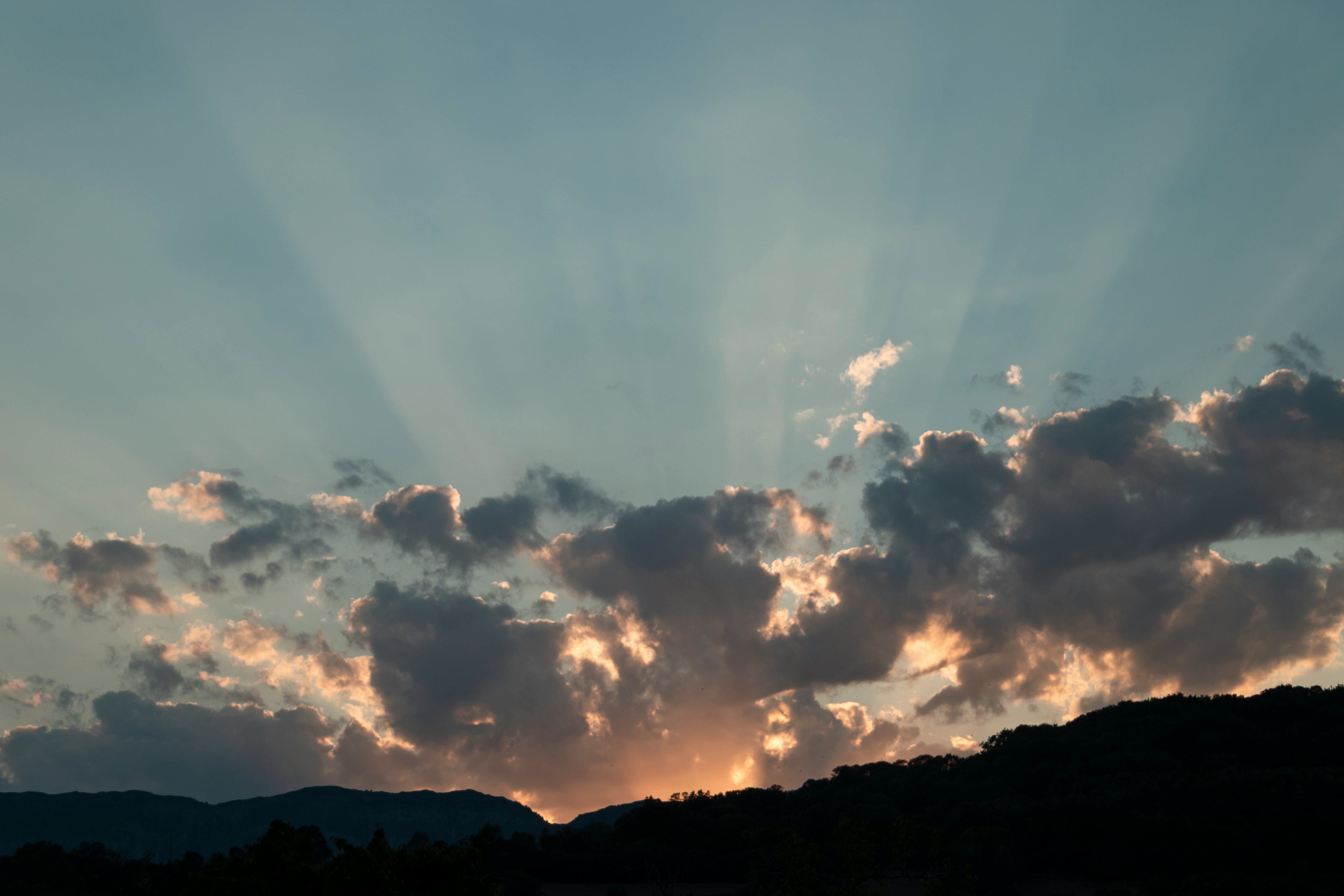 silhouette of mountain under cloudy sky during daytime